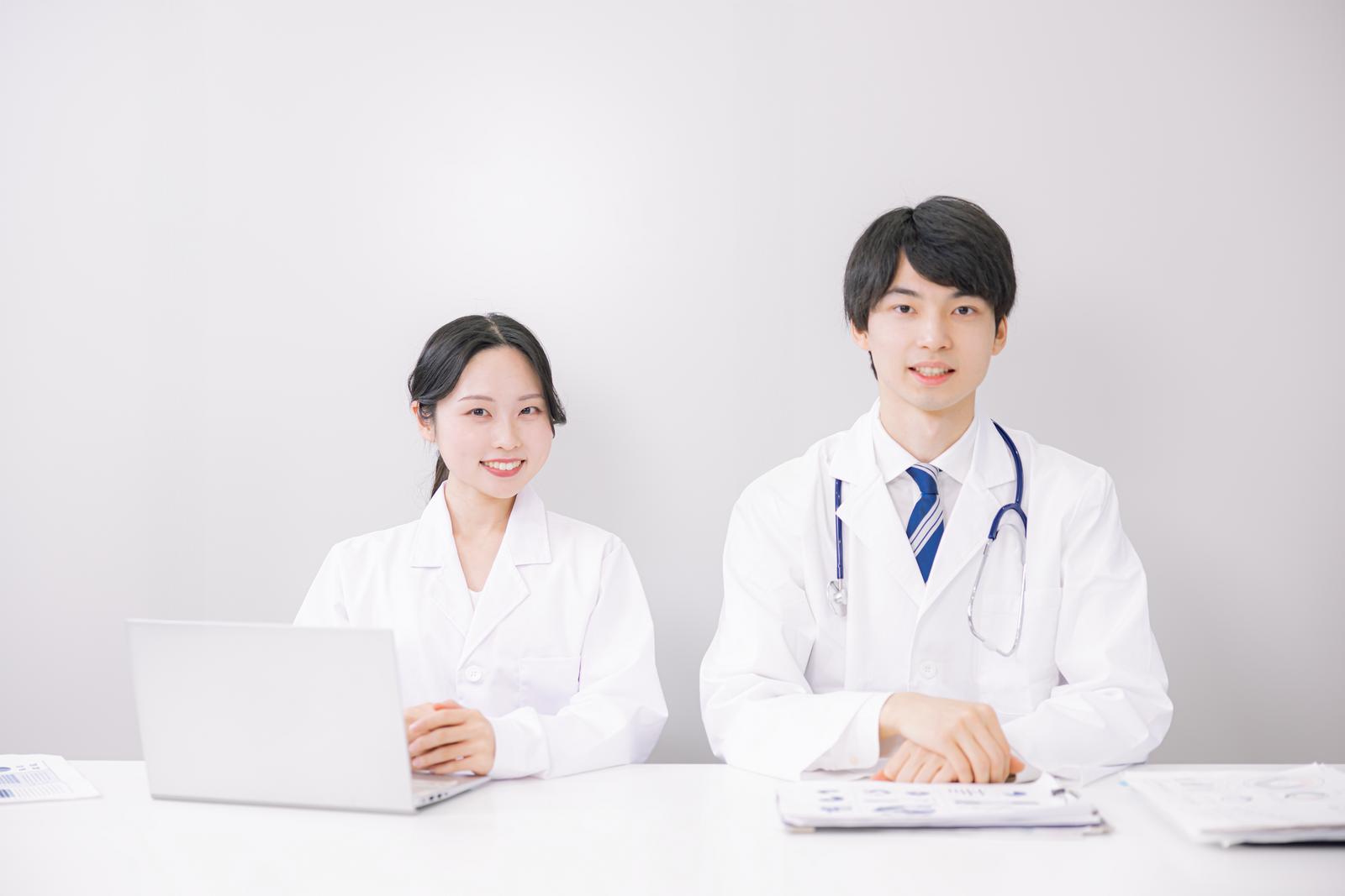 白衣を着た日本人医師がやわらかい表情で相談に応じるイメージ写真